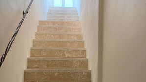 Un escalier muni d’une rampe, qui monte.