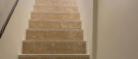 A staircase with a handrail, leading upwards.