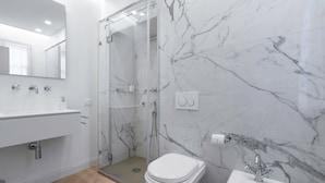 A modern bathroom with a glass-enclosed shower, a white toilet, and a pedestal sink. - Deservi Elegant Apt. Dante (Florence)