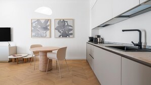 Une cuisine moderne équipée d’une cuisinière intégrée, d’un évier et d’un coin repas avec une table ronde et des chaises.