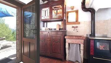 Una cucina rustica con mobili in legno, un piano di lavoro in pietra e una stufa a legna.