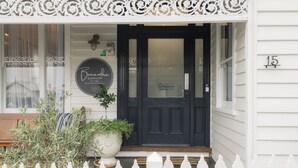 A black front door with a white picket fence in front. - Benambra Boutique Accommodation (Queenscliff)