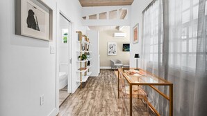 Un intérieur moderne avec un plafond en bois, une table en verre et une bibliothèque blanche.