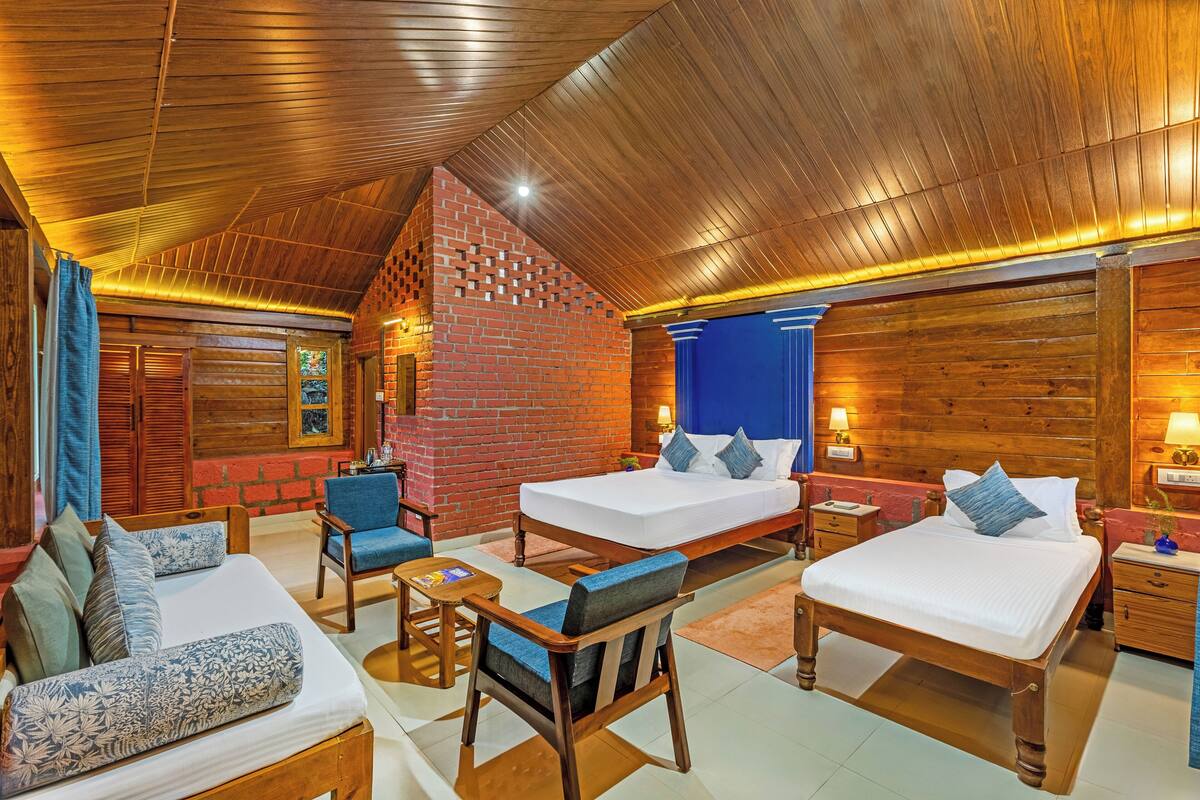A room with two beds, a sofa, and a chair.