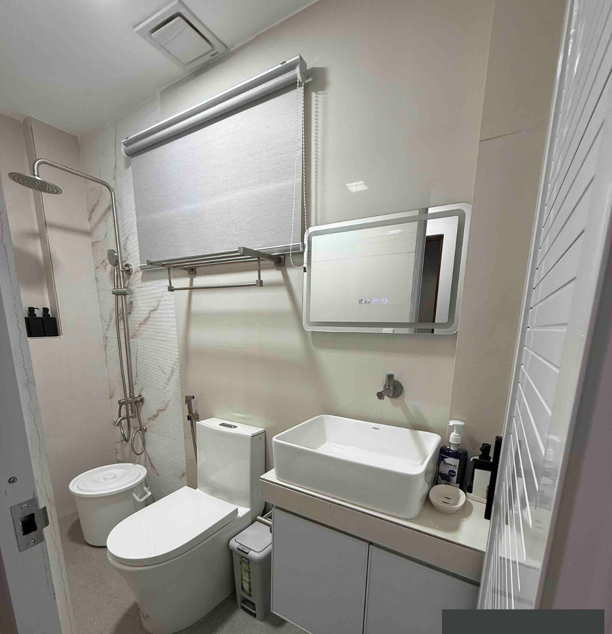 A bathroom with a toilet, bidet, sink, mirror, and shower.