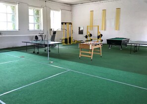 A sports hall with a ping pong table, foosball table, and weightlifting equipment. - Landpension Dubnitz, double room 5 - Landpension Dubnitz (Sassnitz)