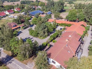 Vue aérienne d’un quartier résidentiel avec des maisons, des arbres et un parking.