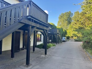 A building with a covered walkway and a car parked on the street.