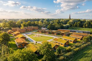 A residential area with multiple houses featuring green roofs, surrounded by lush greenery and a distant church spire. - "Huus Appelboom" Vacation Home in Kating for up to 6 people (Kating)