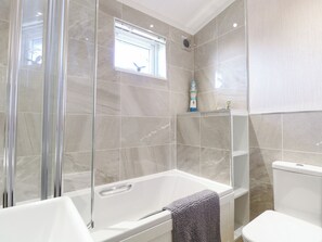 Ein modernes Badezimmer mit einer Duschkabine, einer Badewanne und einem WC.