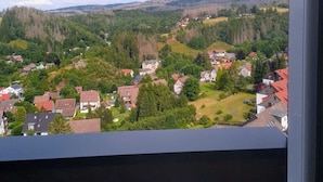 A view from a window overlooking a residential area with houses and greenery.