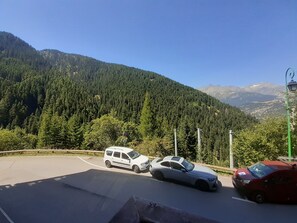 A road with vehicles and a mountainous backdrop.
