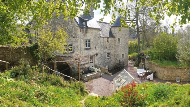 A stone building with a courtyard, a covered seating area, and a view of the surrounding landscape. - Normandieheritage14 - Moulin de la Bretonnière - D-Day Tour Guide: E-bike & Hiking (Moulin de la Bretonnière)
