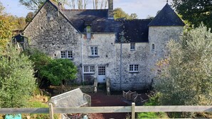 A stone building with multiple windows and a central entrance. - Normandieheritage14 - Moulin de la Bretonnière - D-Day Tour Guide: E-bike & Hiking (Moulin de la Bretonnière)