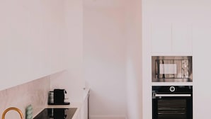 Een keuken met een koffieapparaat, oven en een magnetron.
