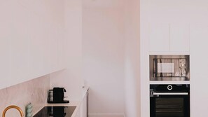 A kitchen with a coffee machine, oven, and a microwave. - Berghaus Bright  - Where design meets the mountains - (Bright)