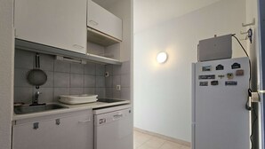 A compact kitchen with a dishwasher, a sink, and a refrigerator.