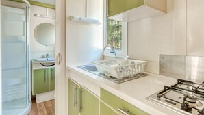 A compact kitchen with a sink, a window, and a stove. - Chalet in Bormes-les-Mimosas with terrace (Bormes-les-Mimosas)
