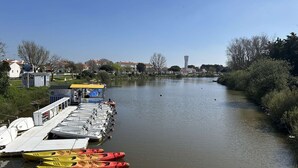 A riverside dock with canoes and a boat rental service.