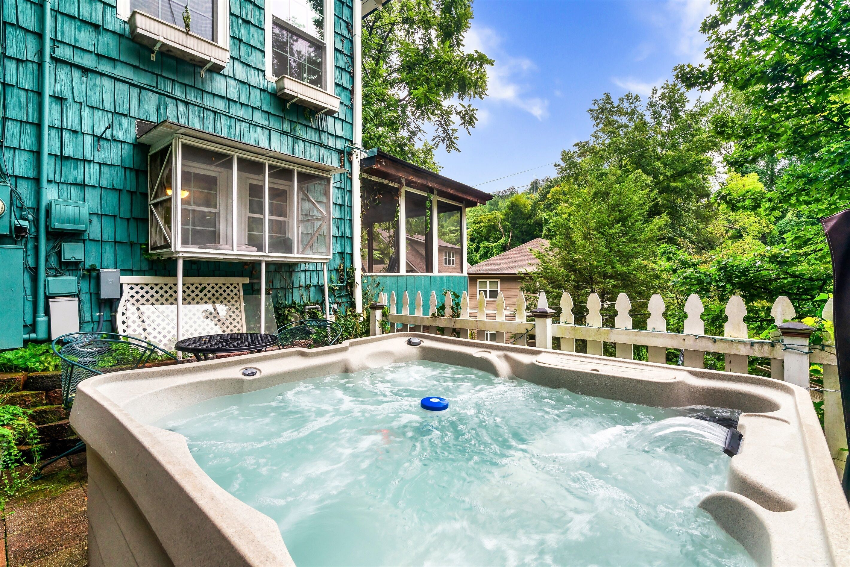 A hot tub in a backyard with a house in the background.