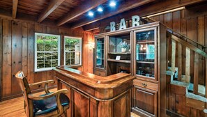 Zona de bar con barra, taburetes y un letrero que dice 'BAR'.
