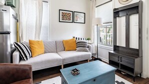 A modern living room with a sofa, coffee table, and a TV stand.