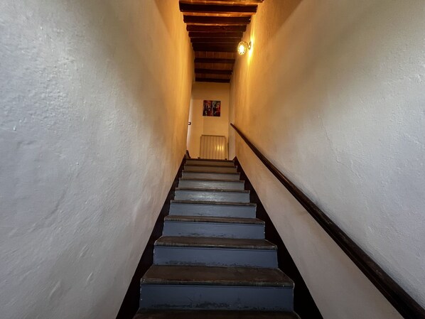 A staircase with wooden handrails and white walls, leading to a door at the top. - Nice apartment for 4 guests with A/C, WIFI and panoramic view (Cortona)