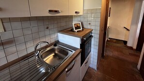 A kitchen with white cabinets, a stainless steel sink, and a wooden countertop. - Lovely apartment for 4 people with WIFI, A/C and panoramic view (Cortona)