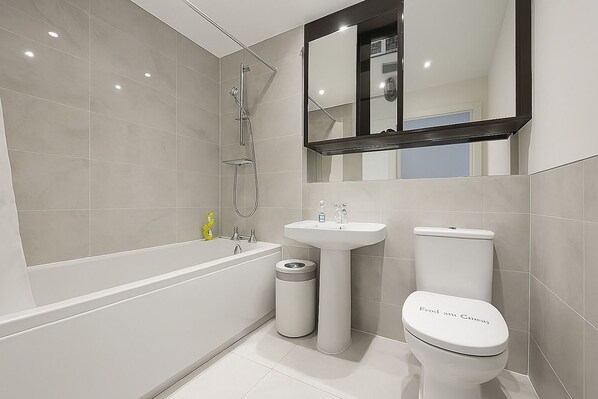 A modern bathroom with a bathtub, a sink, and a toilet.
