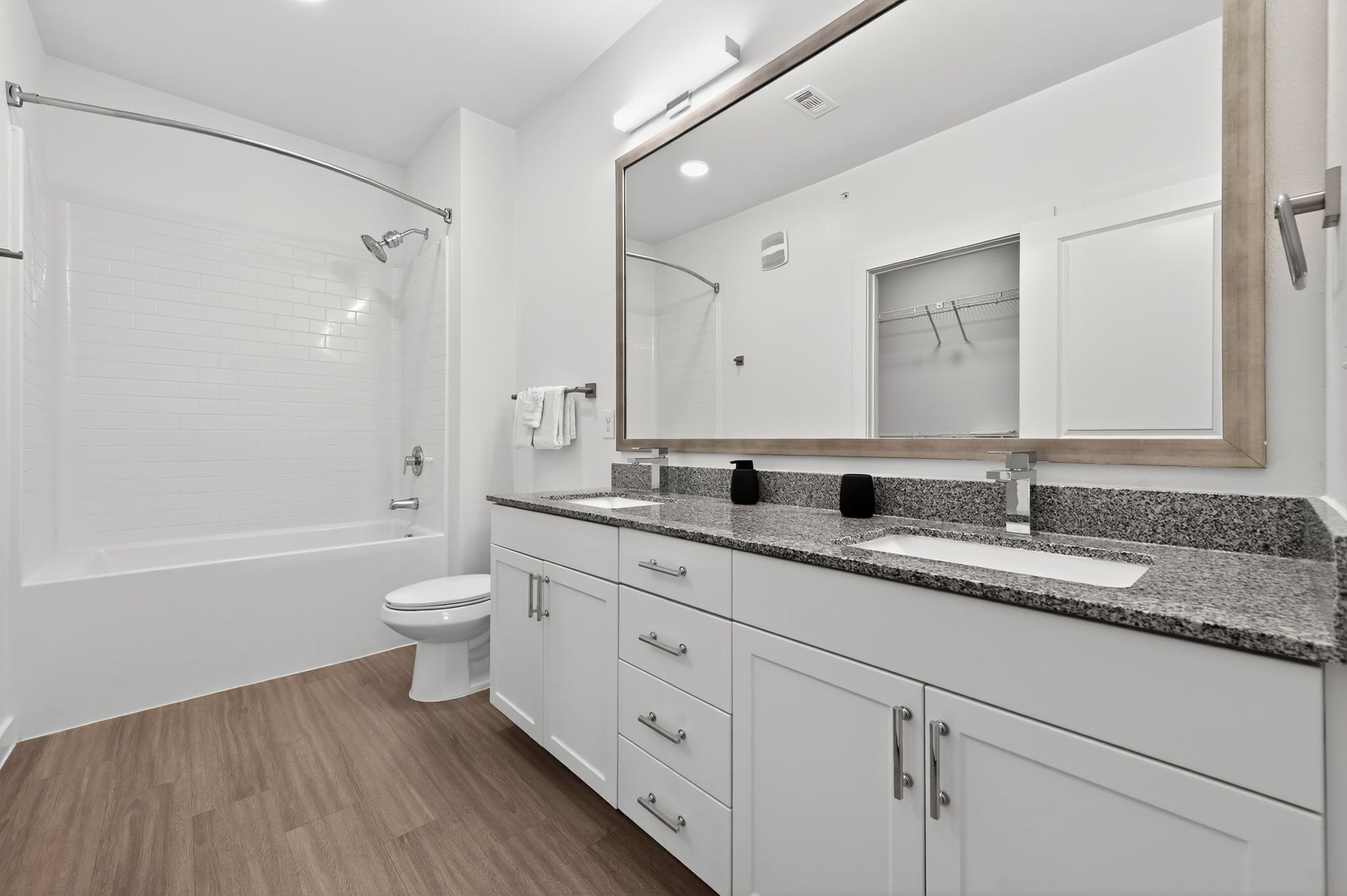 Une salle de bain moderne avec une baignoire, des toilettes, un lavabo et un grand miroir.