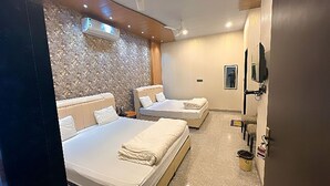 A modern hotel room with a large bed, a small desk, and a ceiling with a unique textured design. - Hotel Shree Shyam Khatushyamji (Danta Ramgarh)