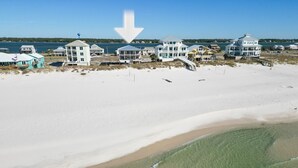 Une propriété située en bord de mer, comprenant plusieurs maisons, une plage de sable et une vue dégagée sur l’océan.