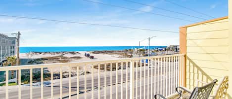 A balcony with a view of a beach and a road.
