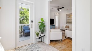 A modern living room with a white sofa, a coffee table, and a ceiling fan.