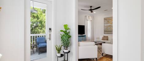 A modern living room with a white sofa, a coffee table, and a ceiling fan.