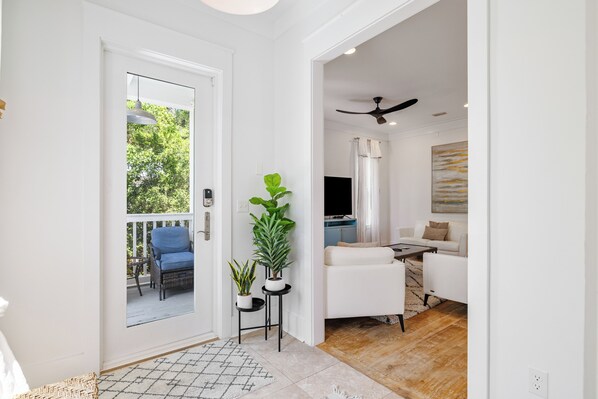 A modern living room with a white sofa, a coffee table, and a ceiling fan.