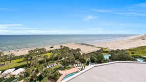 A beach resort with a pool, palm trees, and a view of the ocean. - PH, Balcony, Lazy River, I-O Pools, Game Room, Spa, Beach, Luxury 2-2 Penthouse! (Galveston)