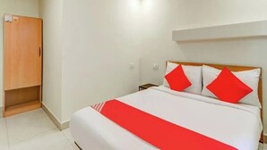 A hotel room with a bed, a wooden wardrobe, and a nightstand. - HOTEL MAGADH REGENCY (Patna)