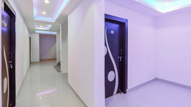 A hallway with a modern design, featuring recessed lighting and a door with a unique pattern. - HOTEL MAGADH REGENCY (Patna)