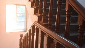Un escalier en bois, doté d’une rampe et d’une fenêtre en haut.