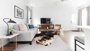 A modern living room with a sofa, coffee table, and a television.