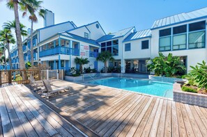 Un hôtel doté d’une piscine, d’une terrasse en bois et de balcons.