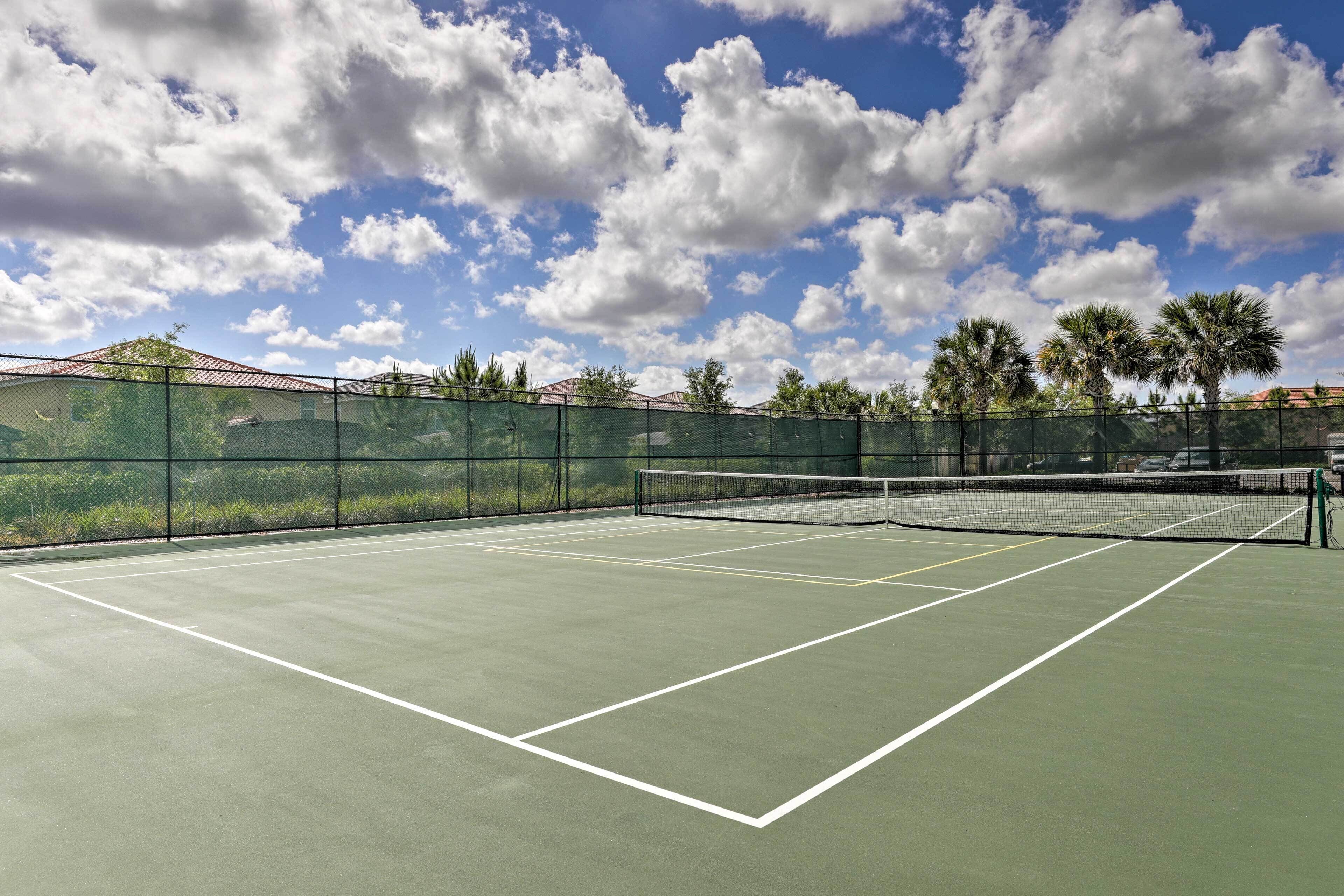 Un court de tennis extérieur doté d’une surface verte et de lignes de démarcation blanches.