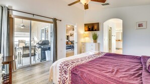 A bedroom with a large bed, a ceiling fan, and a sliding glass door leading to a balcony. - 10 Mi to Disney: Family Retreat w/ Game Room! (Davenport)