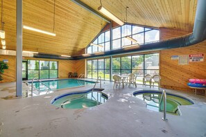 Una piscina interior con varias pistas de natación, techo de madera y ventanas grandes.