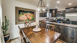 A kitchen with dark wooden cabinets, a stainless steel refrigerator, and a microwave. - Walk to Downtown: Family-friendly Cody Home! (Cody)