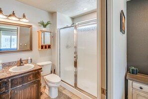 A bathroom with a shower, toilet, sink, and vanity. - Walk to Downtown: Family-friendly Cody Home! (Cody)