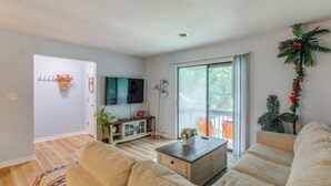 A modern living room with a sofa, coffee table, and a TV. There is a sliding glass door leading to an outdoor area. - 1/2 Mi to Shore: Condo w/ Balcony in Myrtle Beach! (Myrtle Beach)