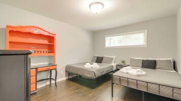 A bedroom with two beds, a desk, and a wardrobe.