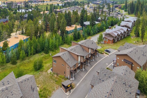 Un quartier résidentiel composé de plusieurs immeubles à deux étages, d’une rue principale et d’espaces verts environnants.